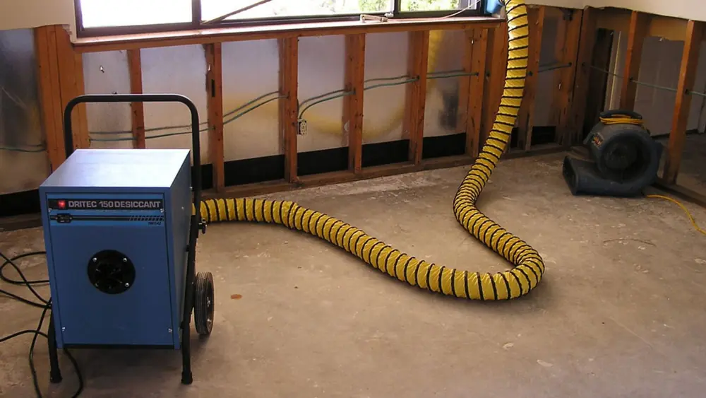 Dehumidifier and ducting drying opened wall framing before repairs begin