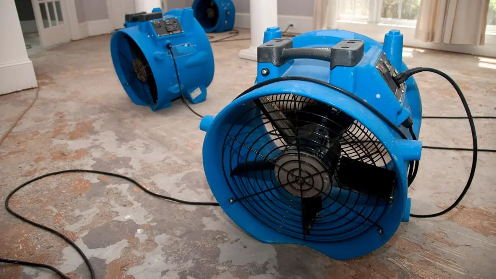 Blue air mover running on a wet concrete floor